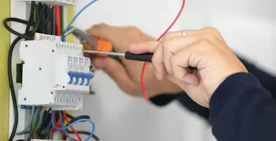 Electrician installing and adjusting circuit breakers in an electrical panel in Pasadena, CA