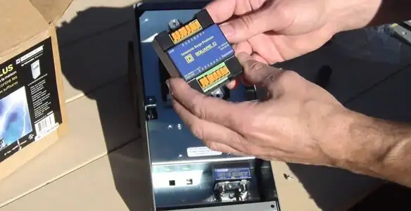 Electrician installing whole home surge protection unit inside main electrical panel in Pasadena, CA