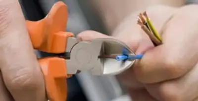 licensed electrician performing precise wire cutting and preparation during electrical service in Pasadena, CA