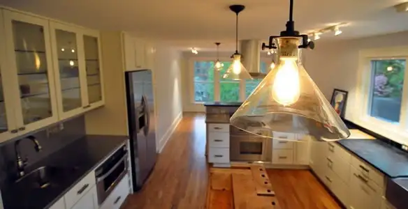 Residential electrician installing modern indoor light fixture in a home in Pasadena, CA