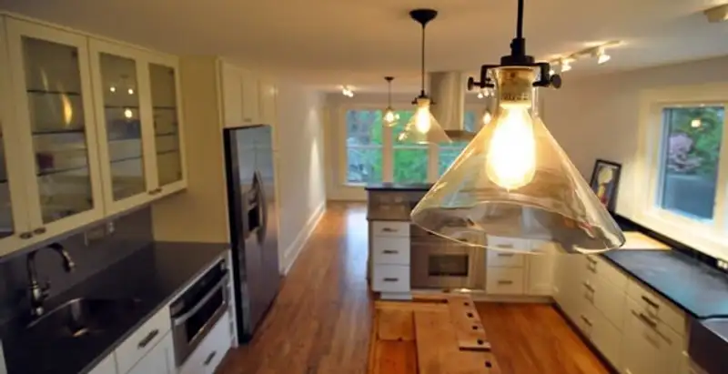 Residential electrician installing modern indoor light fixture in a home in Pasadena, CA
